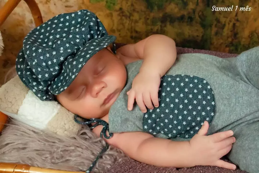 Recém-nascido de 1 mês dormindo com touca de bolinhas.